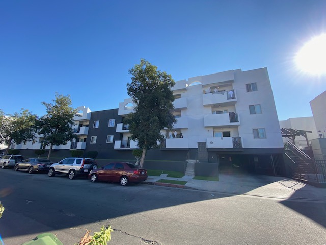Street view of Harmony Gates Apartments, multilevel building with parking in building