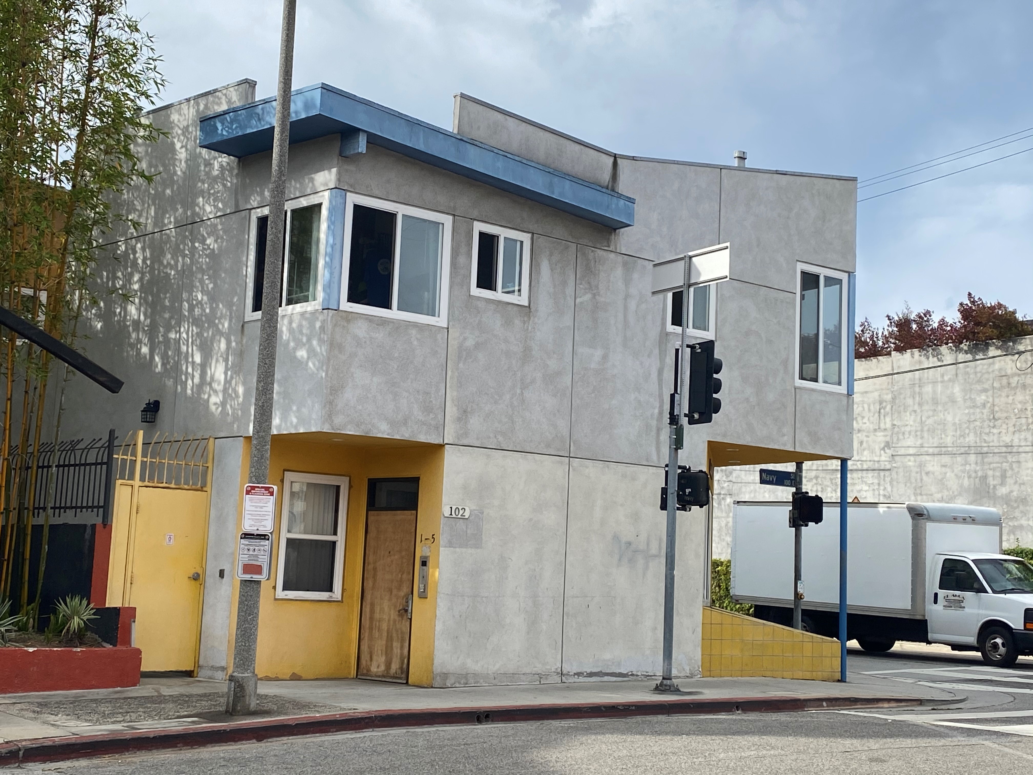 Street view of Navy Street Apartments. A grey, yellow and blue 2 story building