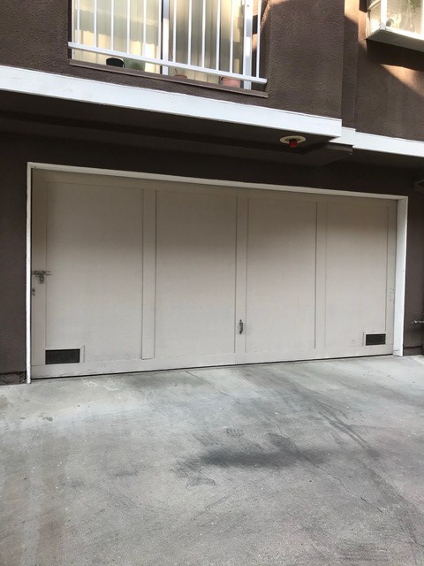 Garage door with lock on left hand side and handle in the center.