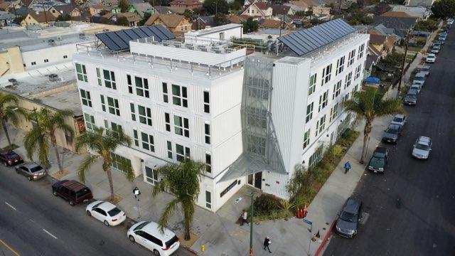 Front View  of  Hope on Broadway,  white building four stories.  Solar  Panels on the roof top.