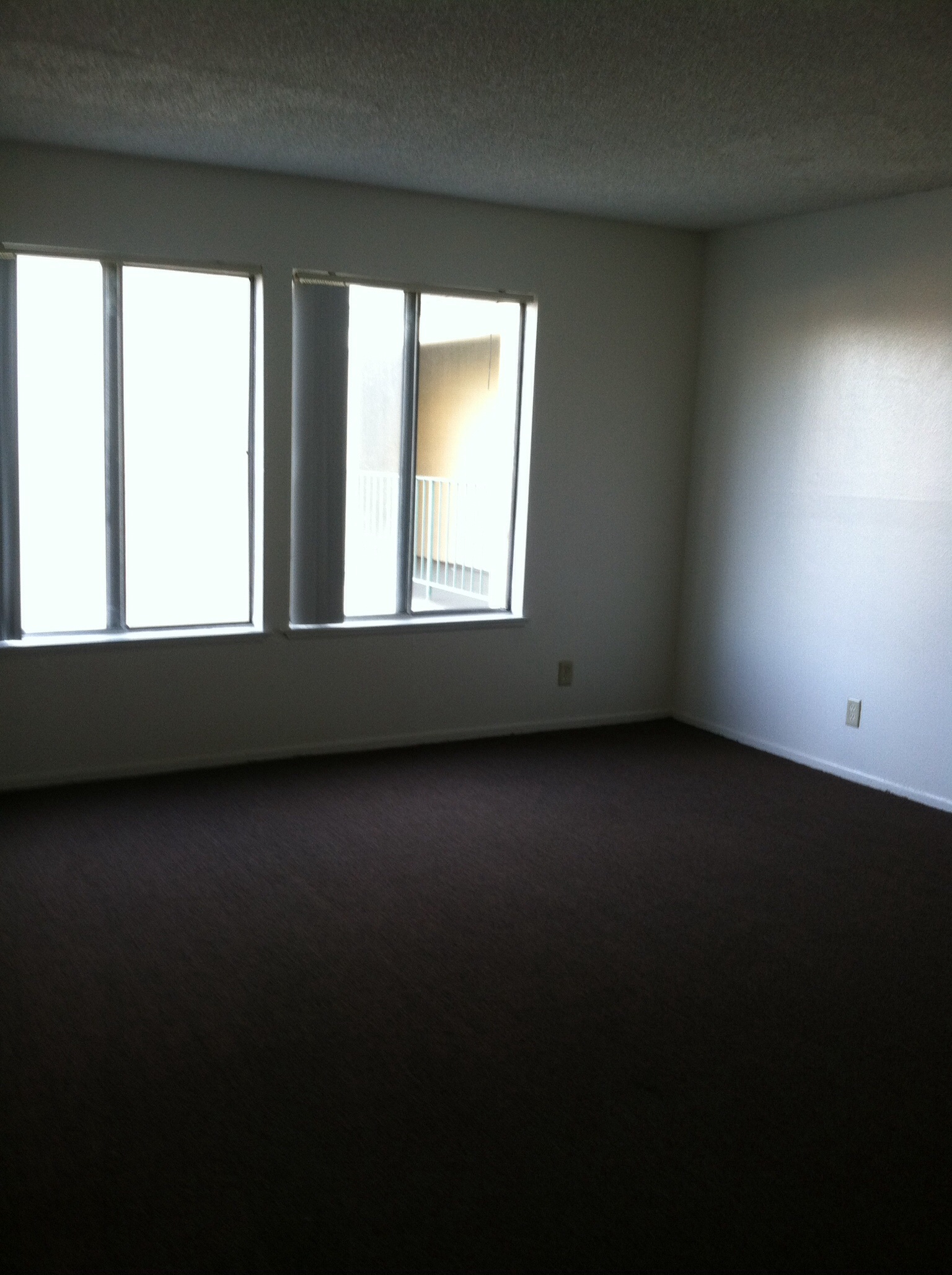Interior view of an empty room in a unit at Ingram Preservation Properties showing two side by side large windows