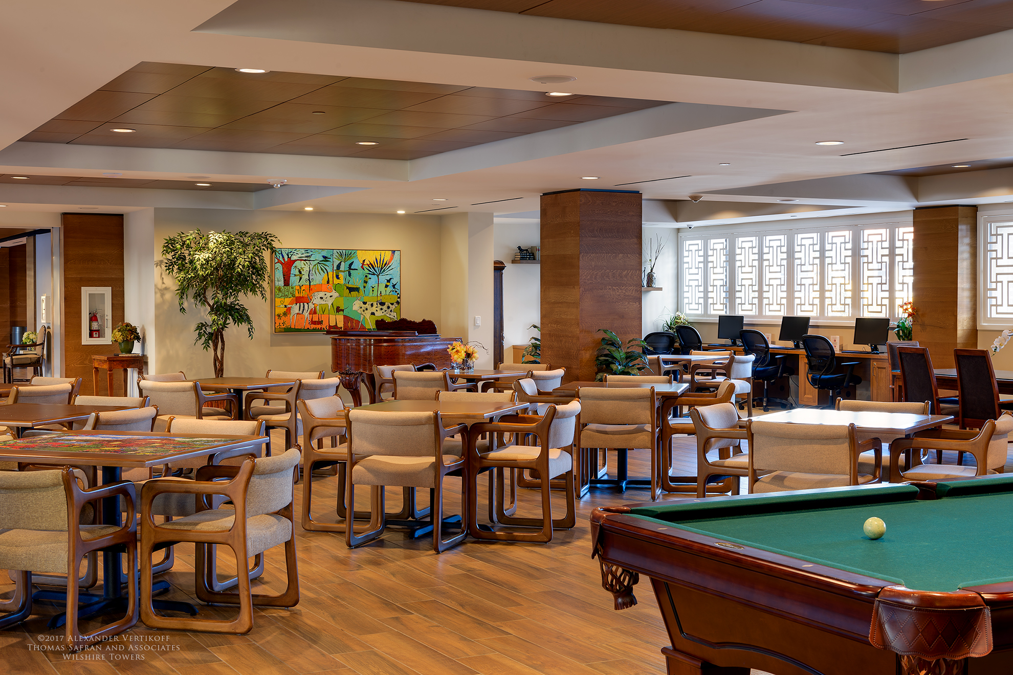 Image of community floor equipped with pool table, furniture, bar, computers and piano