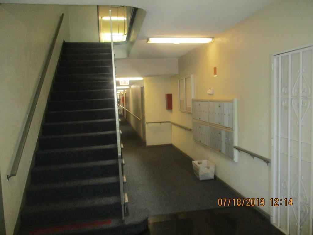Interior view of a property with stairs leading to the upper level and mail boxes on the opposite side