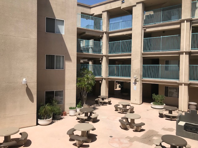 View of an interior courtyard. There are tables with benches in the courtyard.