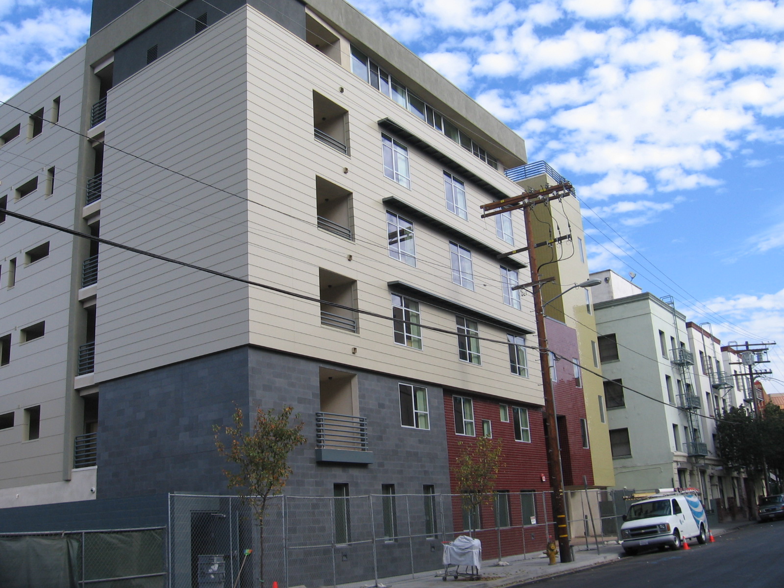 Photo of the Street view of a five story building in gold, brown and gray colors with windows