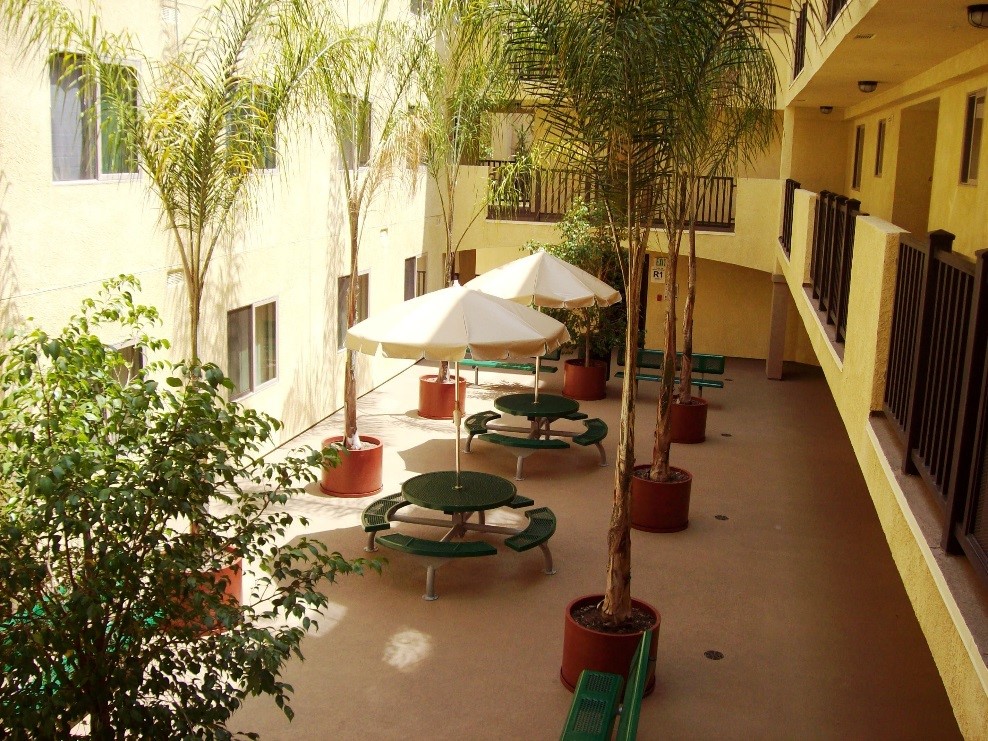 Manitou Vistas II courtyard area with benches and tables with umbrella coverings