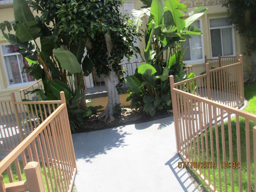 Image of fenced in walkway with landscaping.