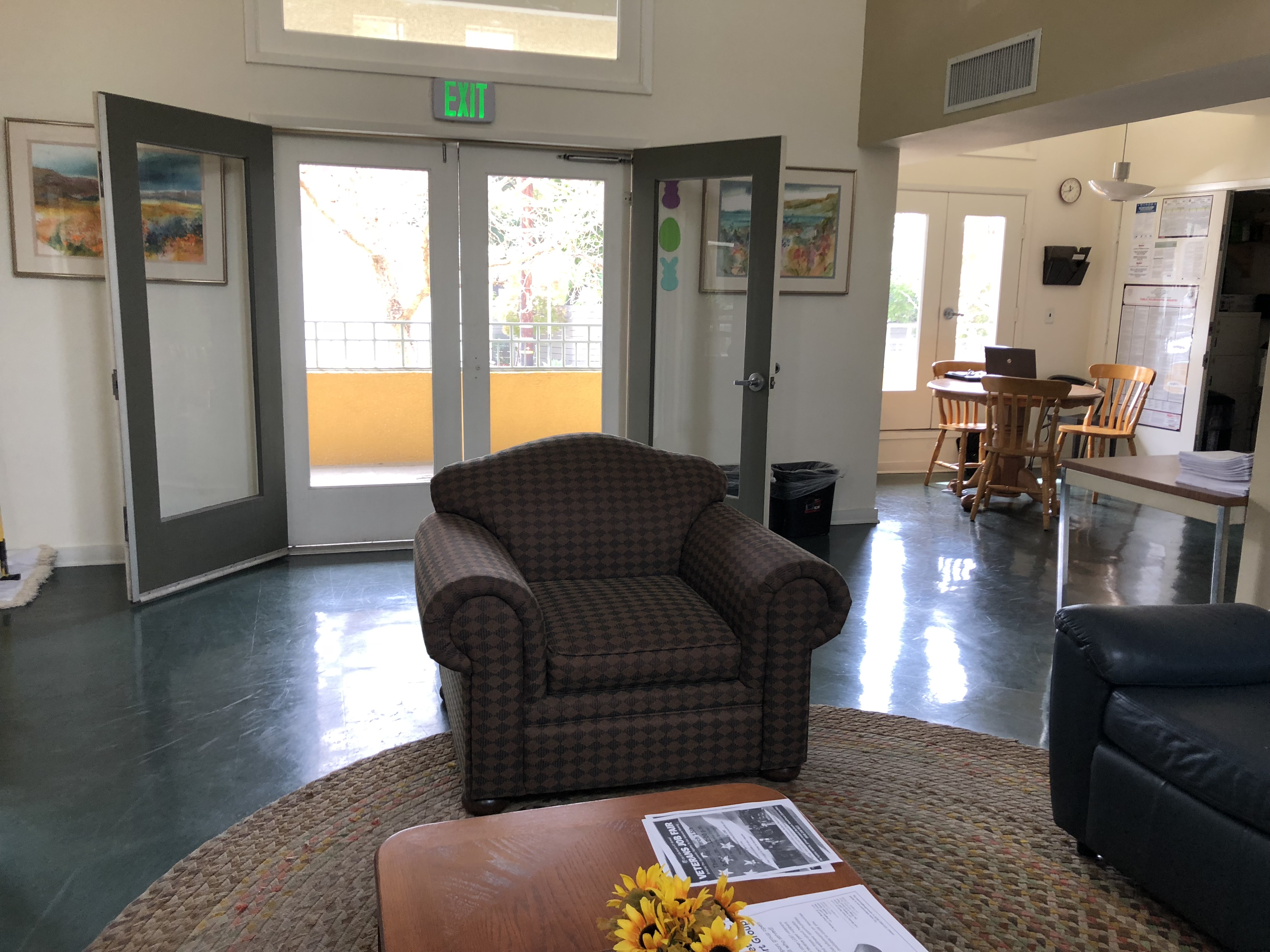 French doors that lead into common room area. Room has 
lots of natural light. Seating area in front of entrance with coffee
table. Another seating area next o large windows with a dining table.