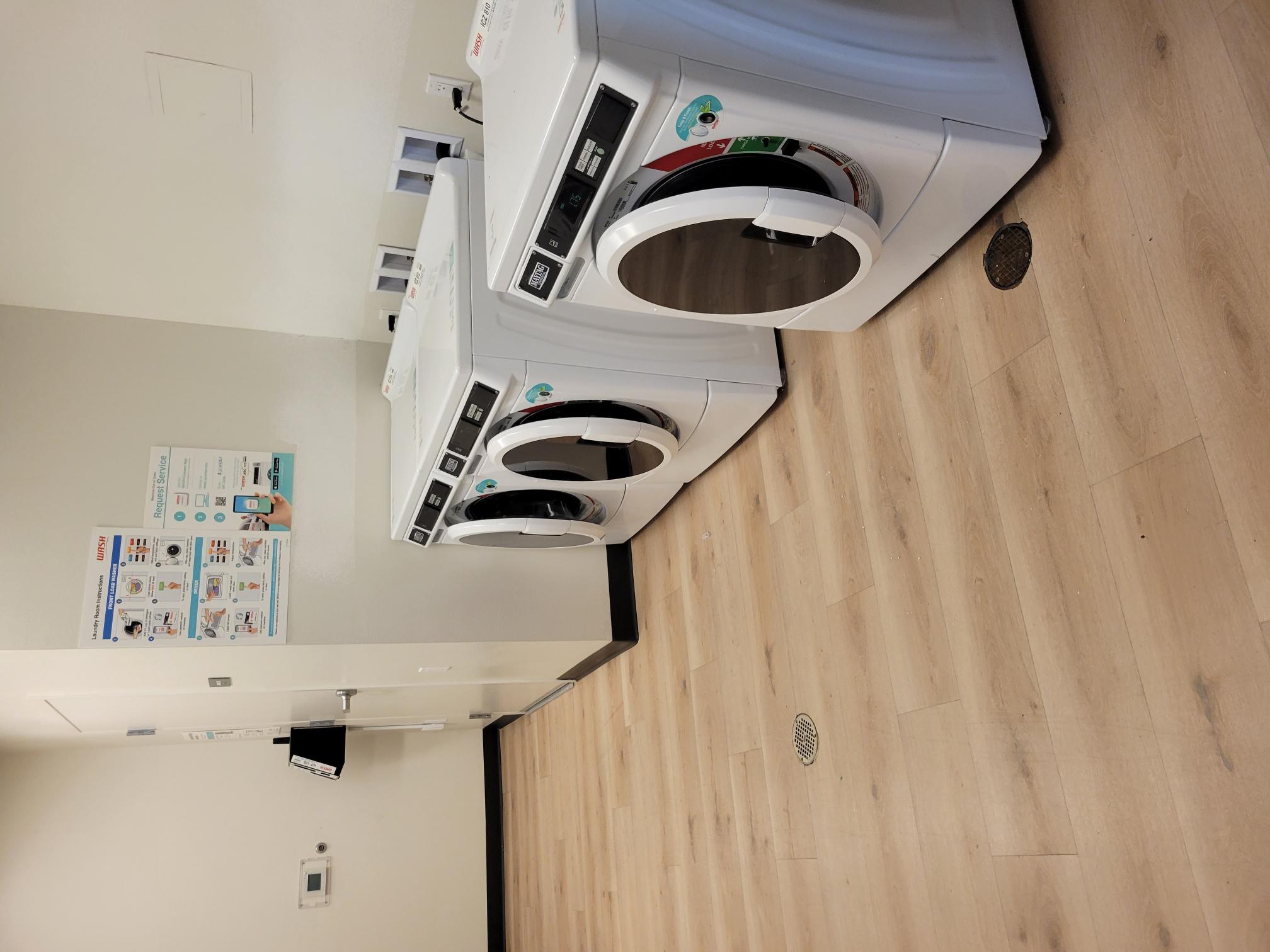 Image of three washing machines in laundry room.