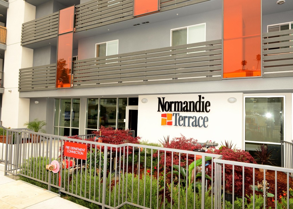 An entrance to Normandie Terrace with a Black and Gray Normandie Terrace Sign