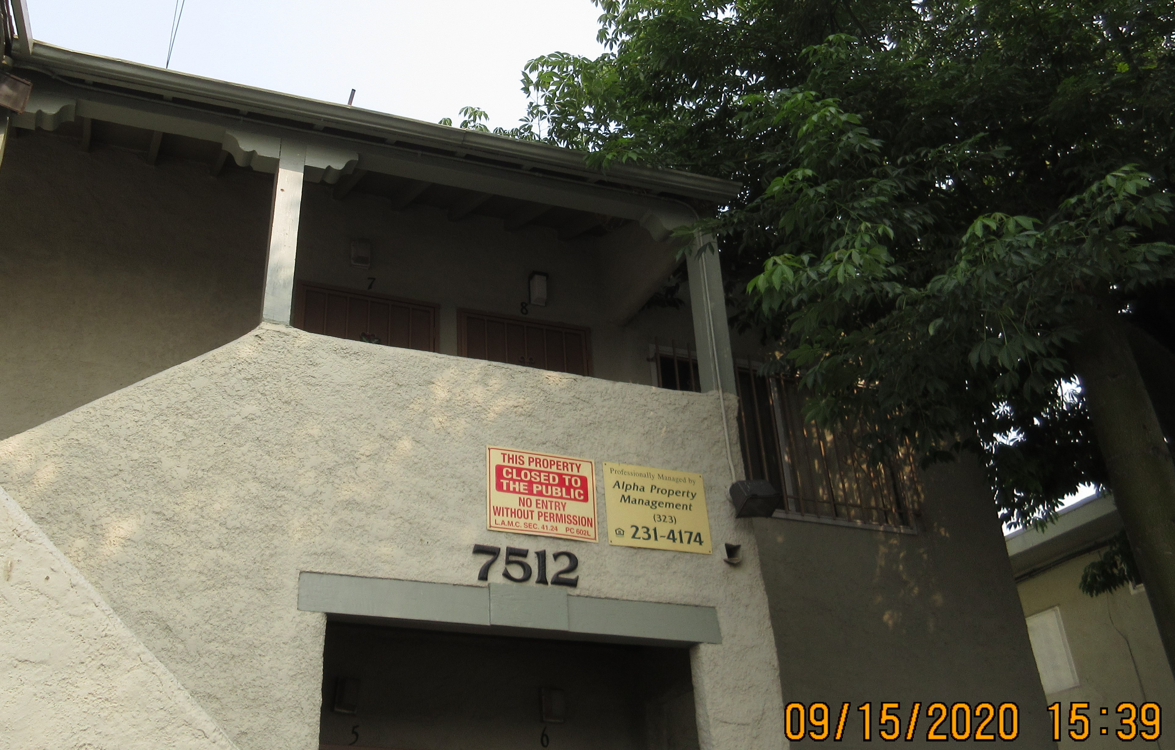 Front view of signs posted on a building wall, Closed to the public, management name and phone number sign.