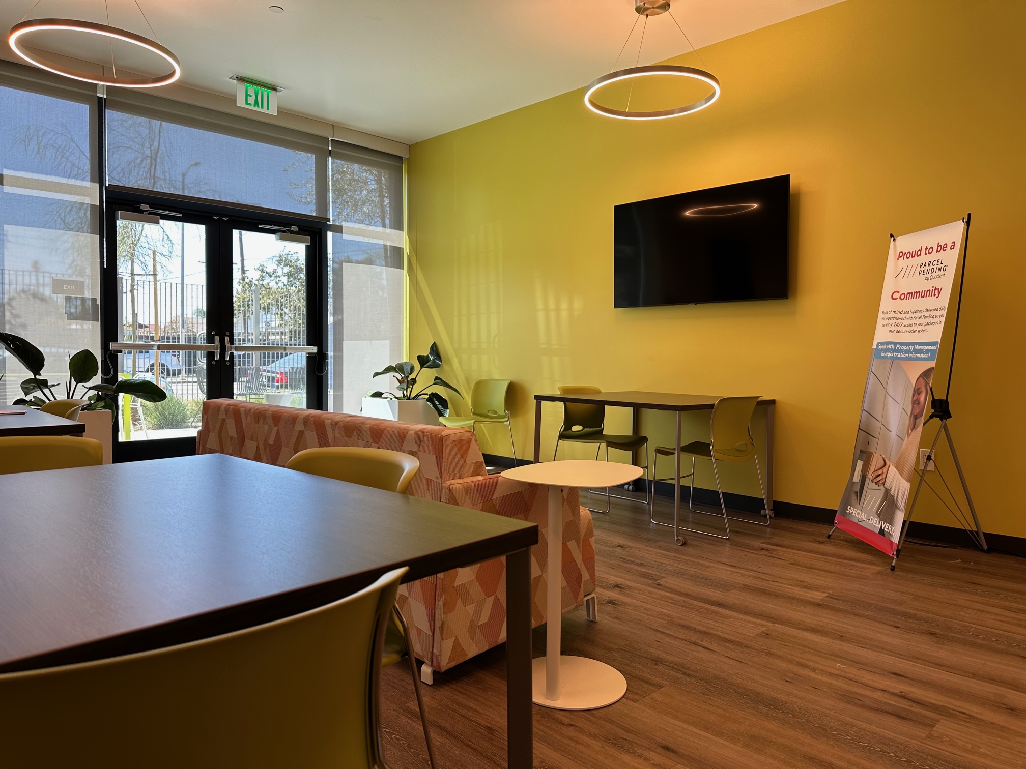 Office or Community Room with table and chairs, sofa and to circular lights hanging from the ceiling.