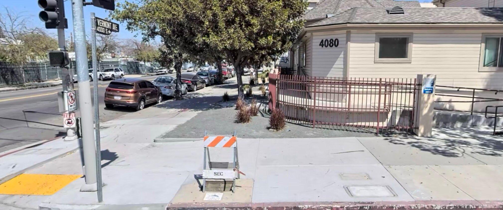 Photo of the apartment, with a fence, on ramp access and trees.