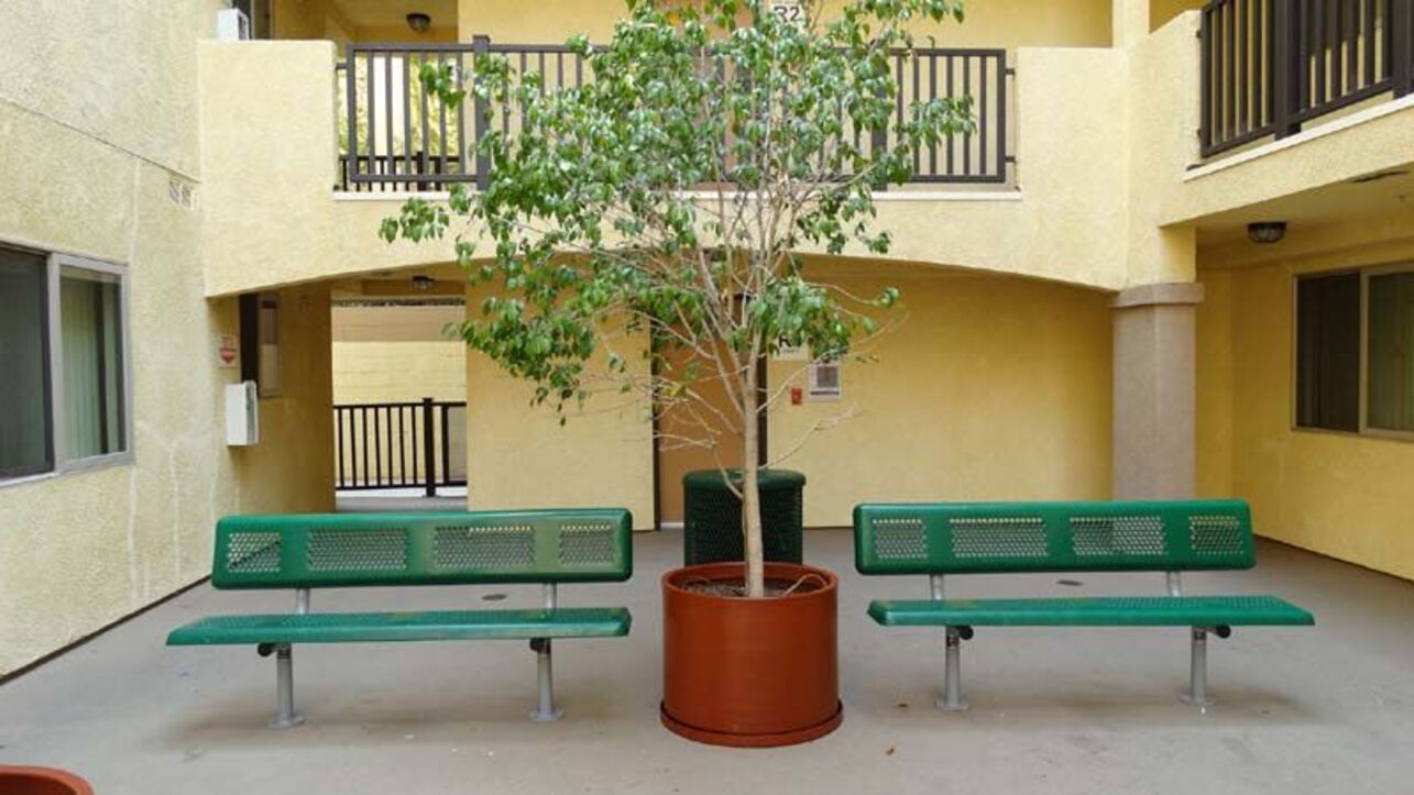 Courtyard seating area with two green benches