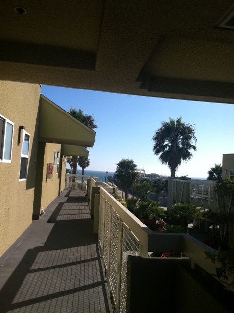 View of top floor outisde walkway that over looks the property. 
With views of the ocean down the street