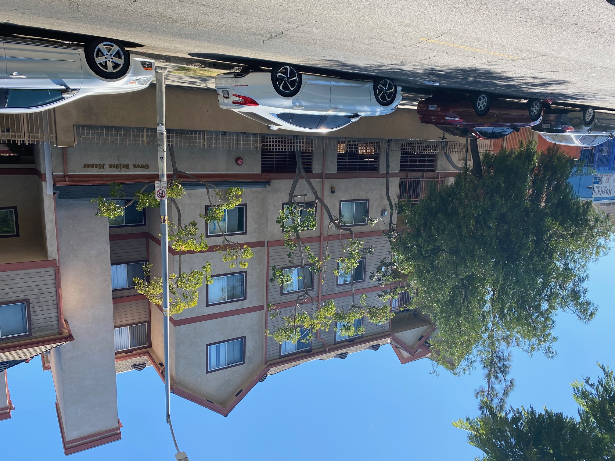 Street view of a three story brown apartment building