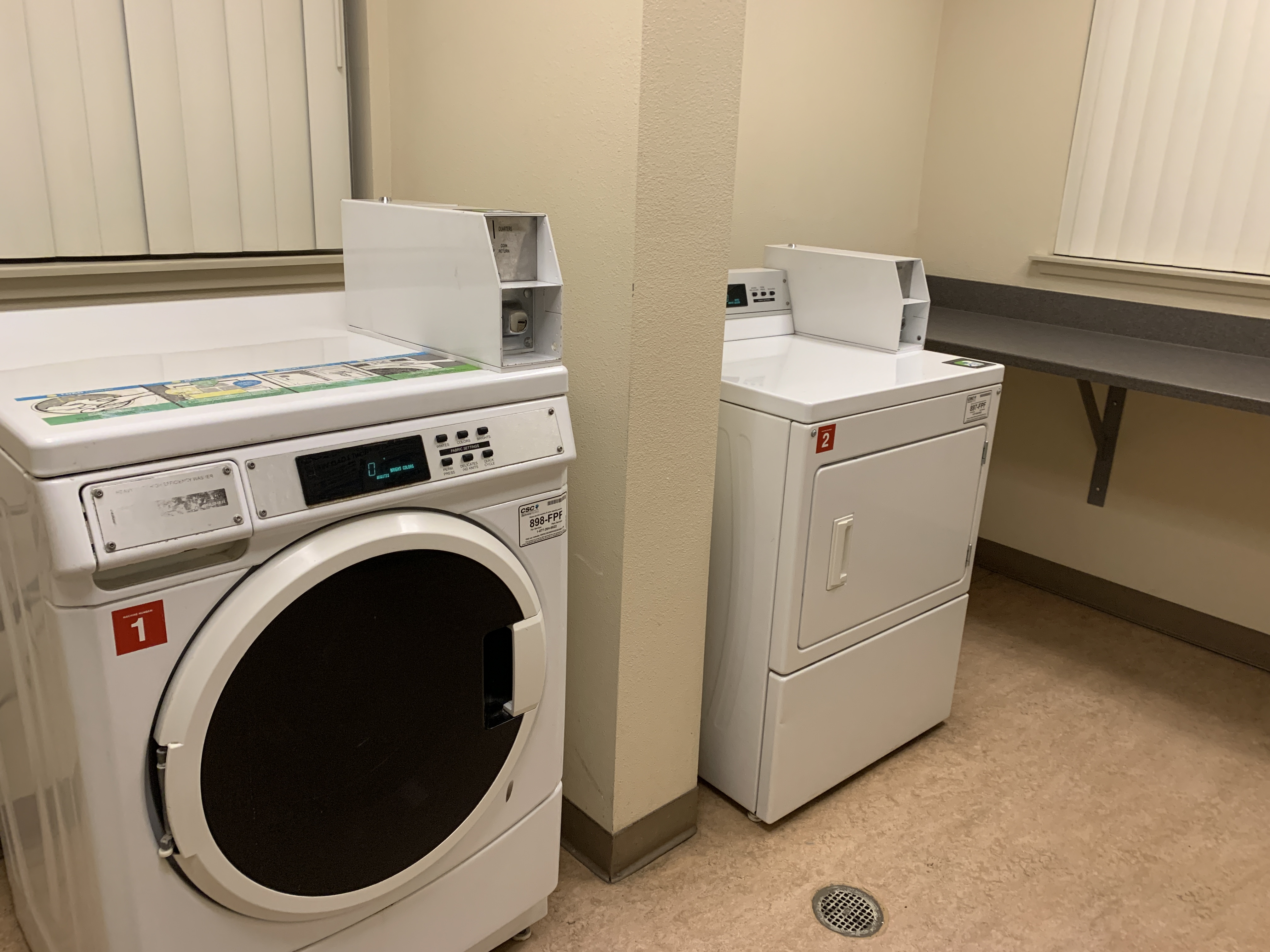 Willis Avenue laundry room. side by side washer and dryer setup. counter top area next to dryer