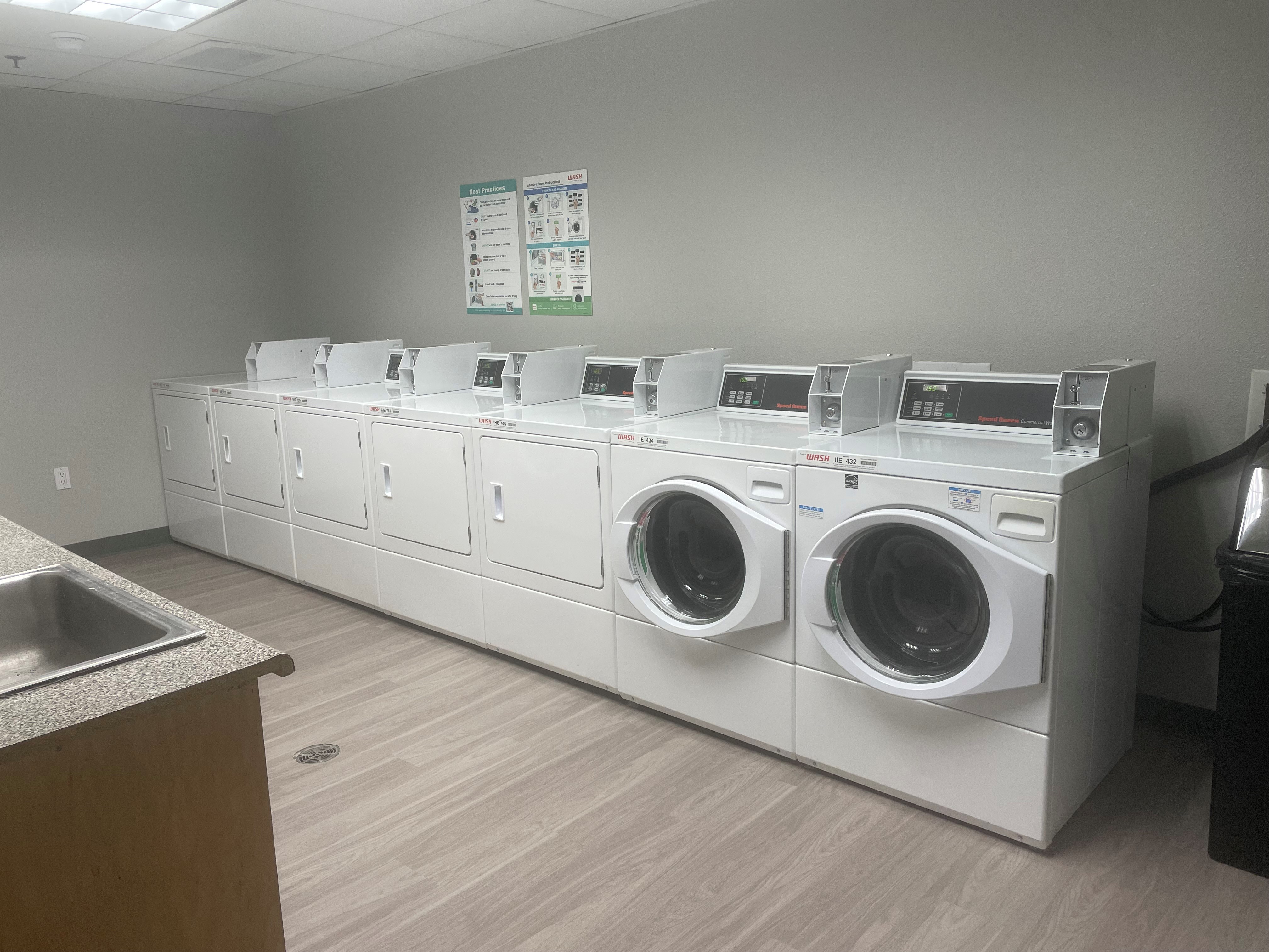A row of washing machines in the laundry room.