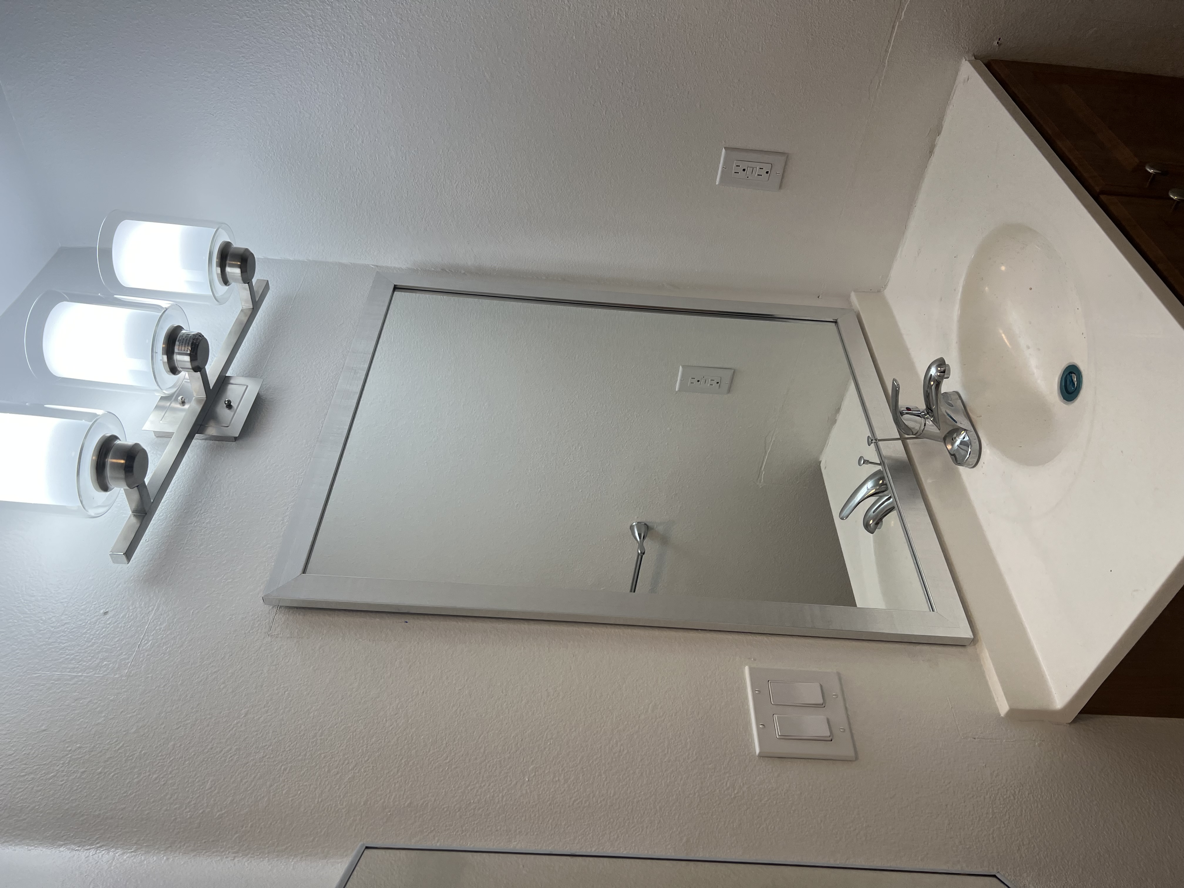 Photo of an empty bathroom showing a white sink and mirror