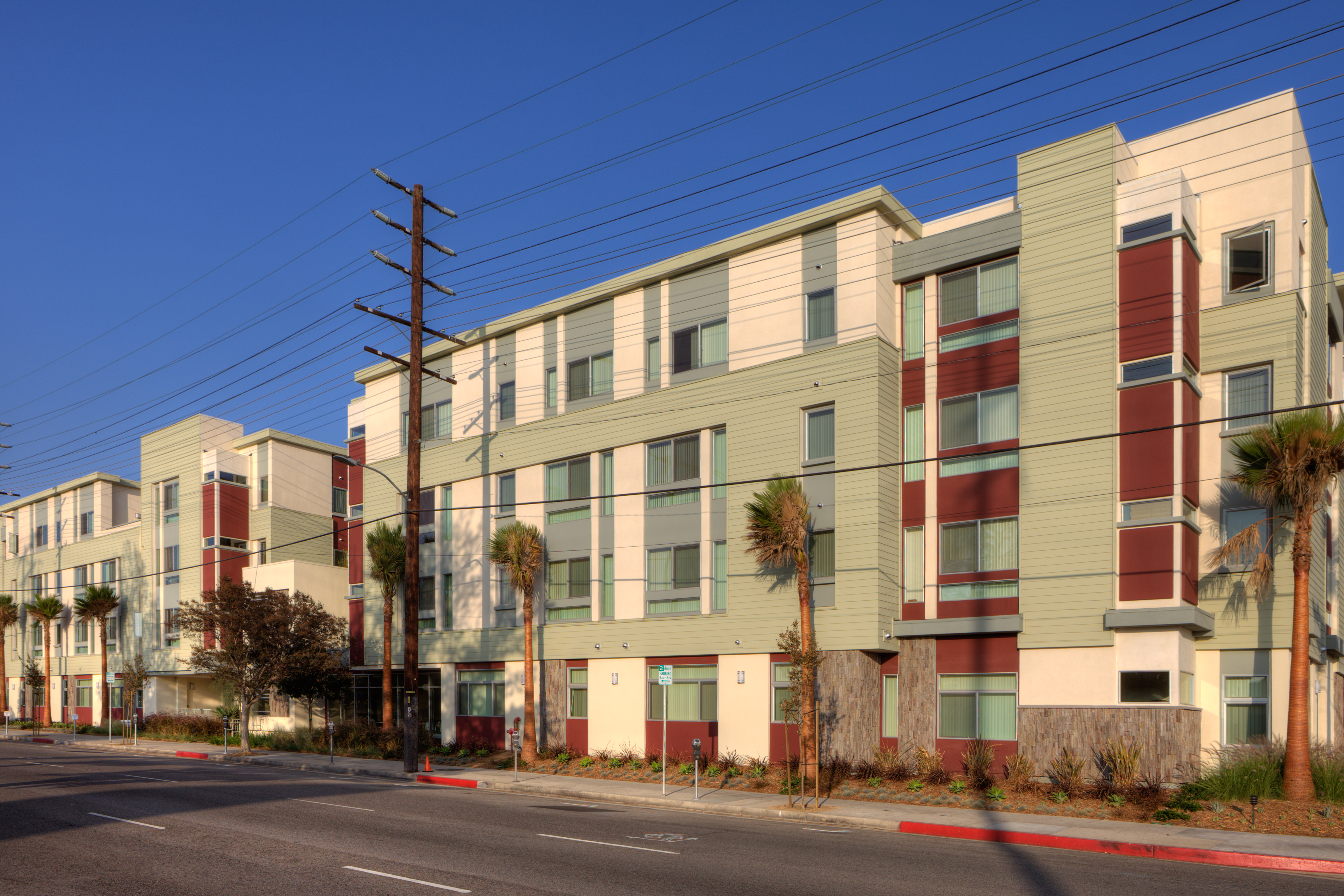 Street view of a four story apartment building in multiple colors