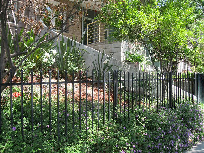 Side view of flower beds and bushes, trees.