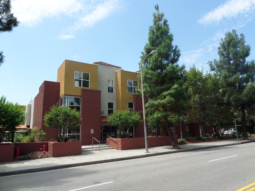 Street view of Castlewood Terrace ll showing multicolored 3 story building with different size trees in front of building