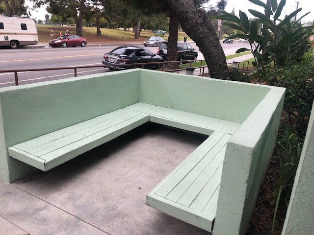 A built in concrete and wood U shaped bench.