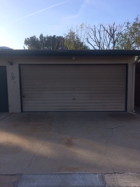View of garage door with light fixture on the left side.