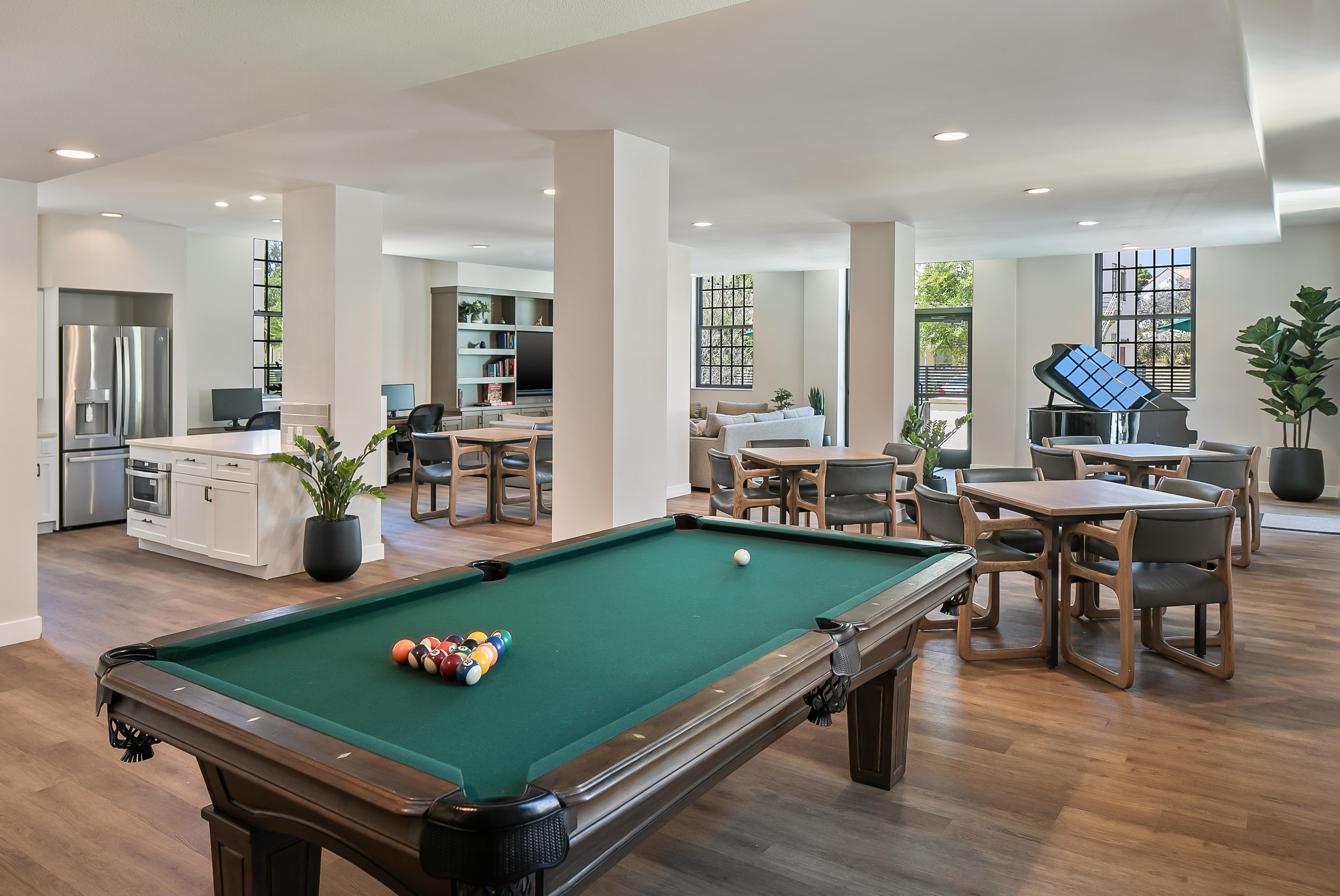 Large lounge with pool table, grand piano, and kitchenette