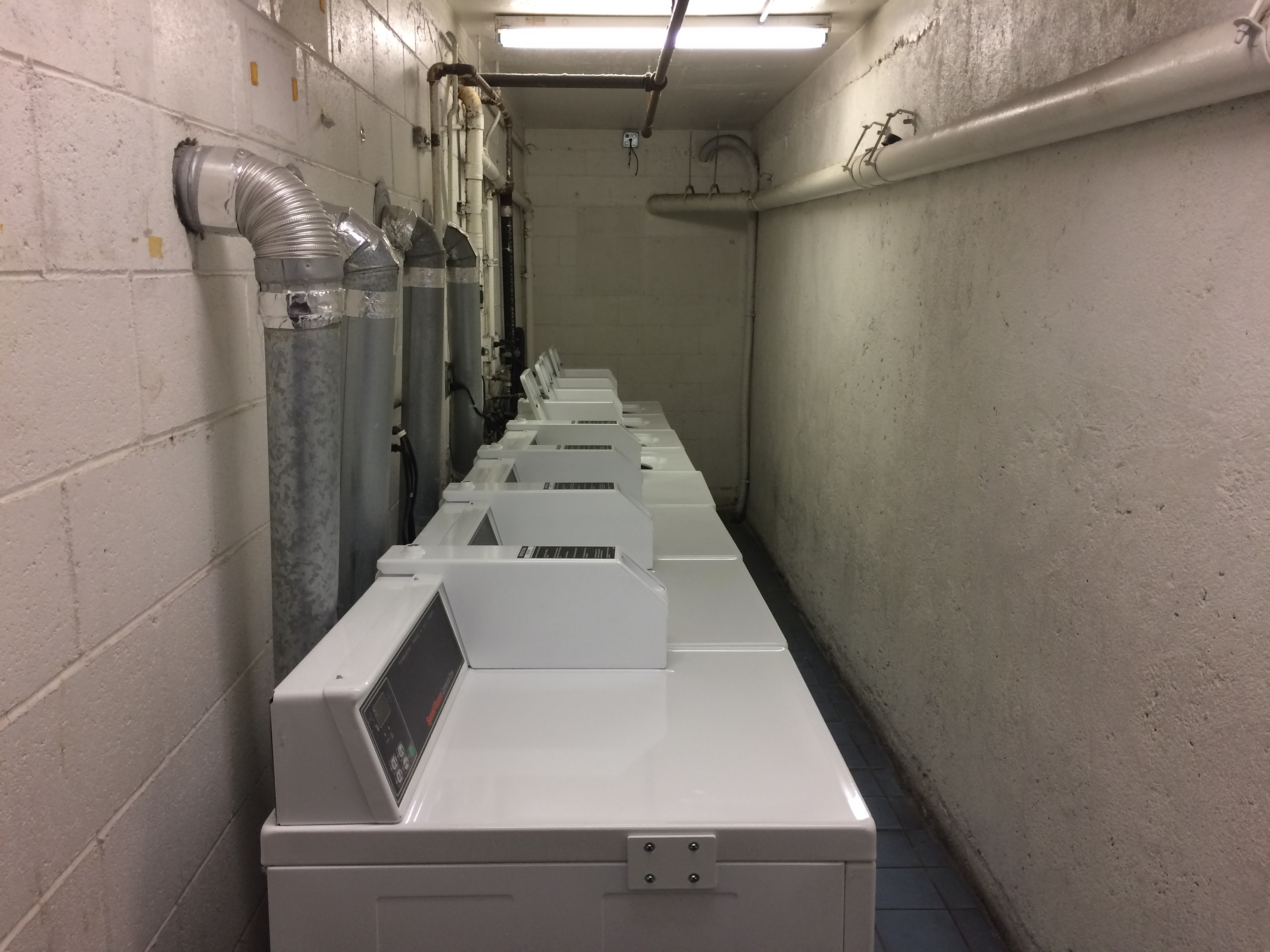 Image of witmer city lights laundry room. Narrow laundry room with four top load washers and four front load dryers