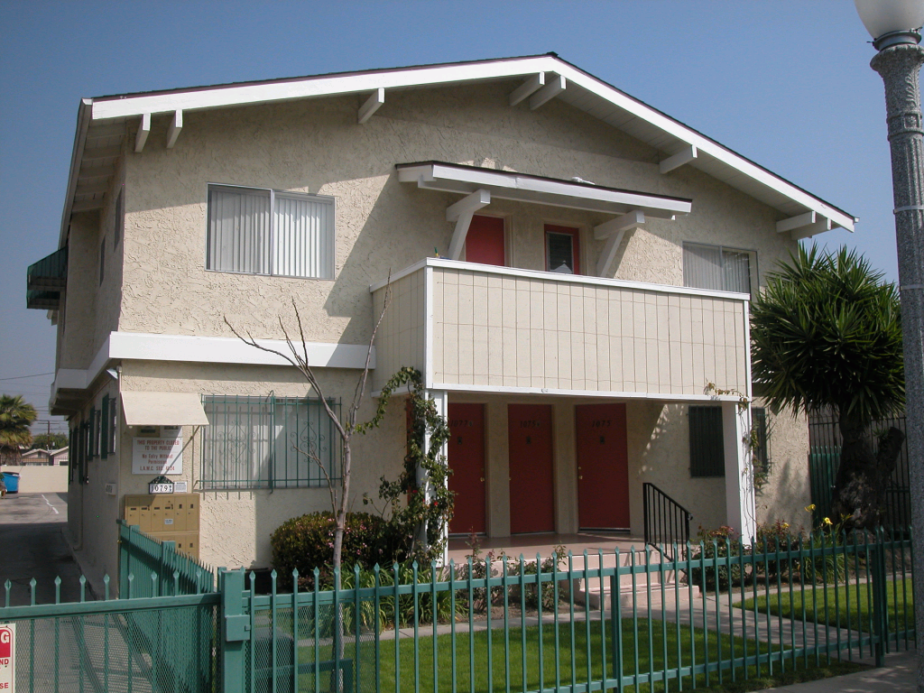 Street view of double story gated building. Small steps leading up to units. Select units with balcony and access to outside parking behind building.
