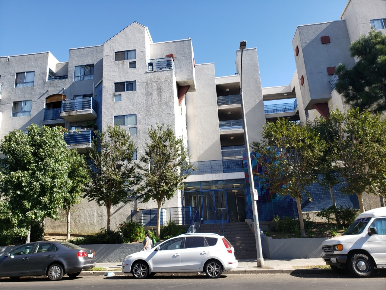 Front view of Marina Apartments. Multi-level building with select units with balcony access. Stairs leading up to front entrance of building