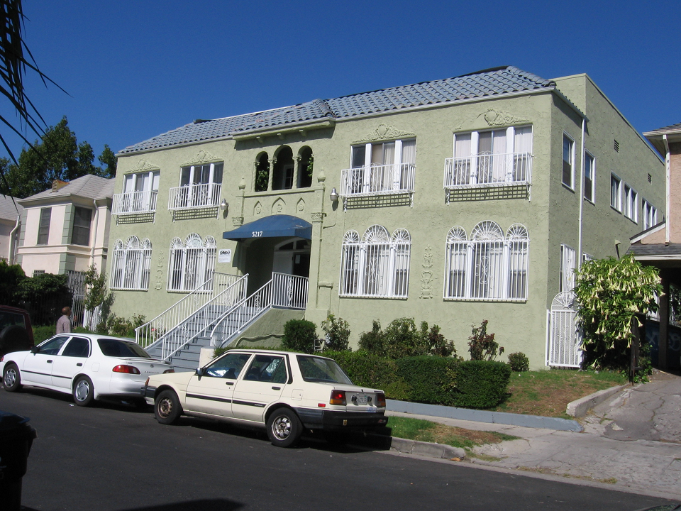 Street view of Queen Apartments. Two story building with stairs leading to front entrance.Street parking available